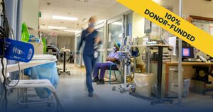 A doctor walks through a busy emergency department