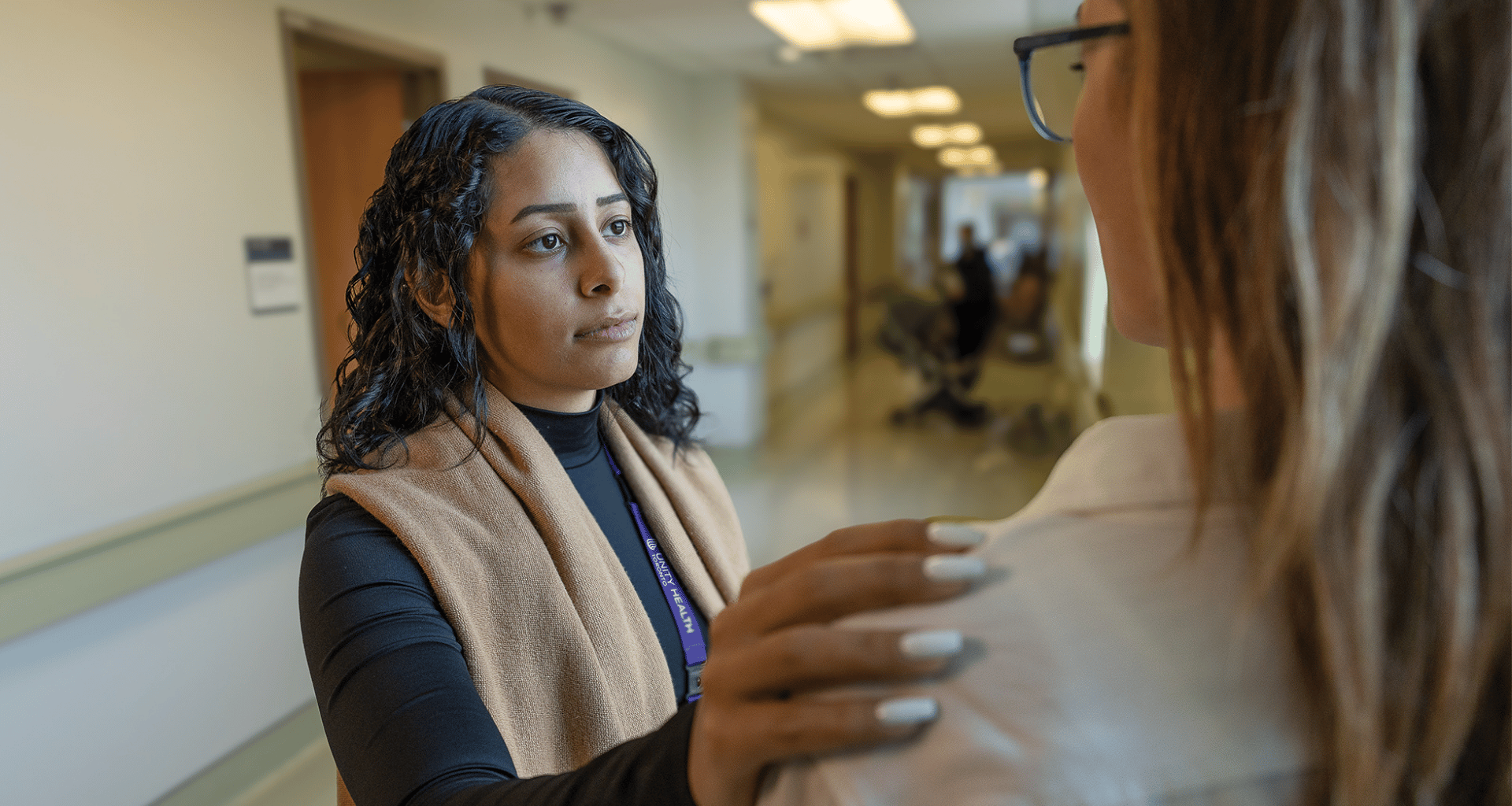 Patient in mental health department with therapist's hand on her shoulder