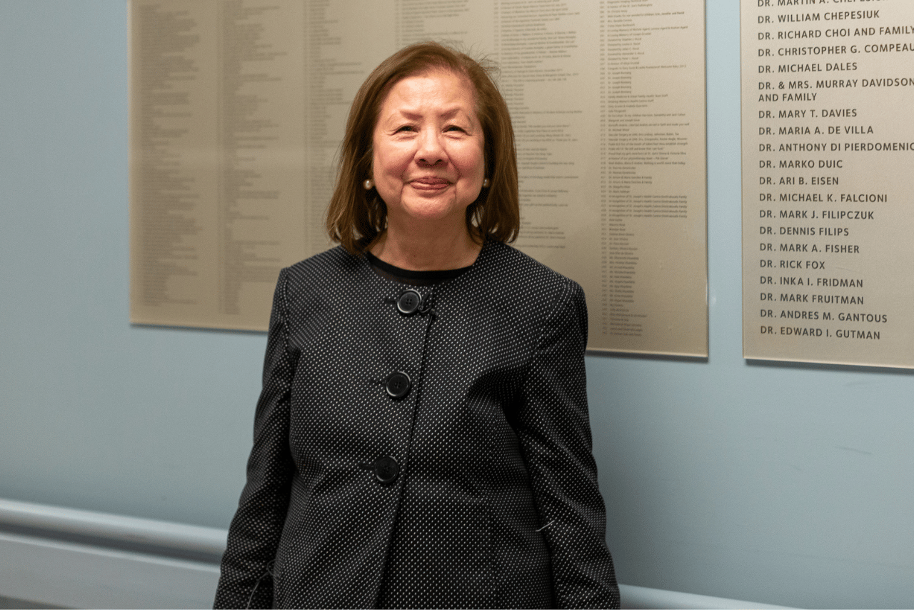 Dr. DeVilla standing in front of a donor wall