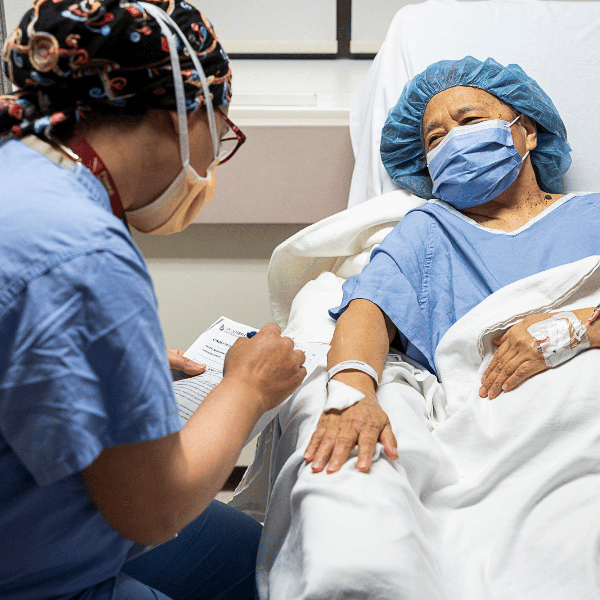 A nurse helping a patient in a hospital bed